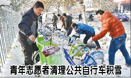 青年志愿者清理公共自行车积雪