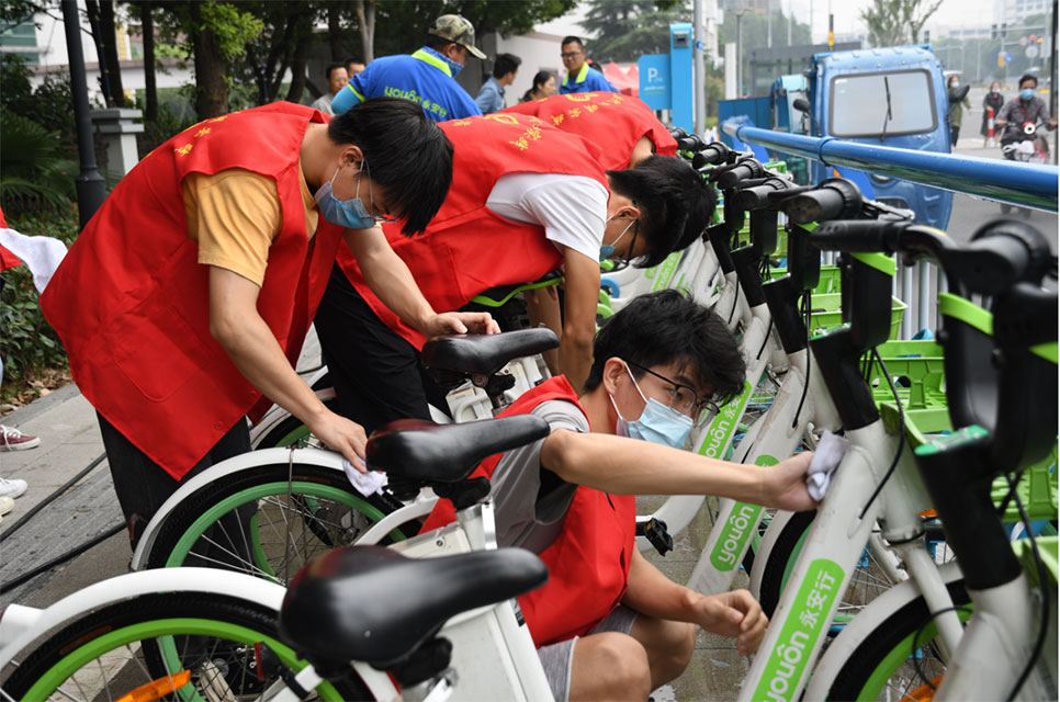 世界无车日，志愿者走上街头擦亮共享助力车